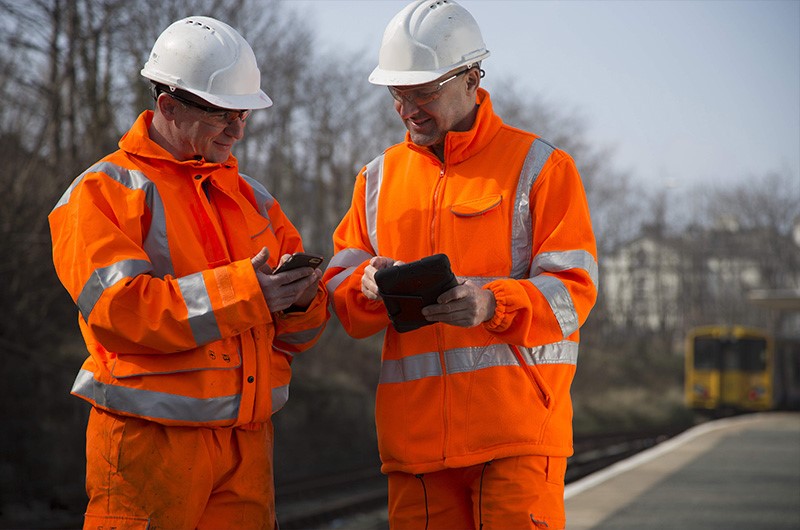 two rail workers scanning smartcards