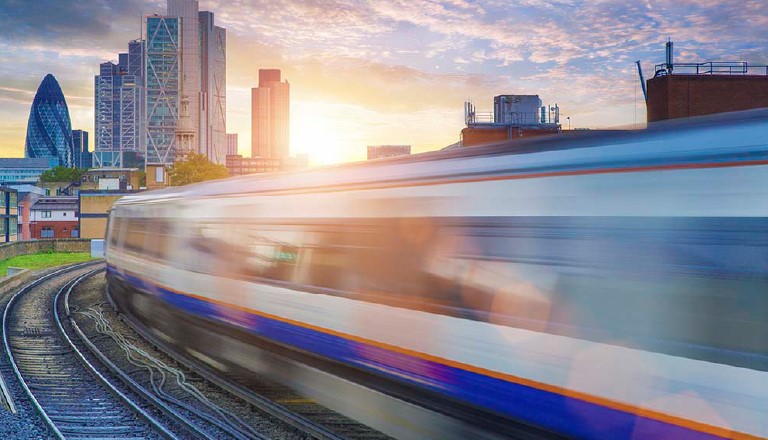 A train running with London city behind