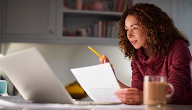 A lady studing with a laptop and a notbook