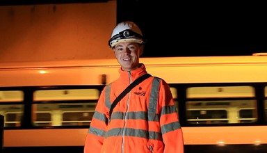 Rail worker with train in view